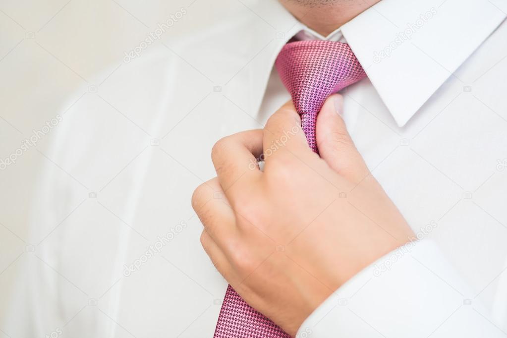 Groom tying tie