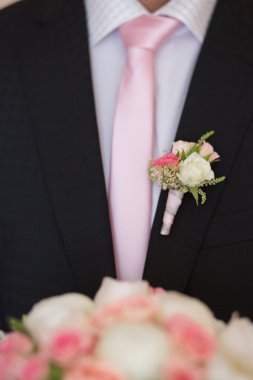 Boutonniere on trendy groom at wedding clipart