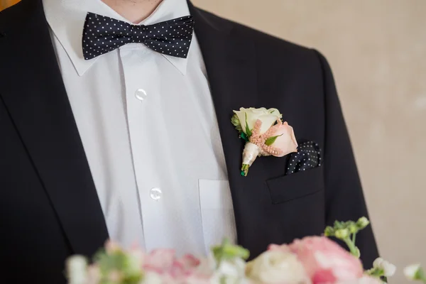 Бутоньерка на модном женихе на свадьбе — стоковое фото