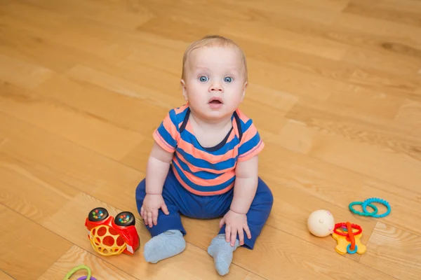 Дитячий хлопчик грає з іграшками в приміщенні вдома — стокове фото
