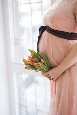 Hamile kadın karnına dokunuyor.