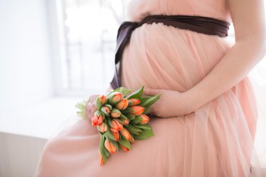 Hamile kadın karnına dokunuyor.