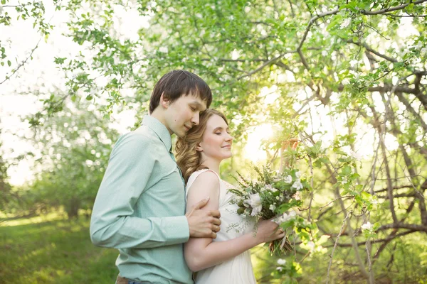 Amore coppia in piedi tra albero di mele in fiore — Foto Stock