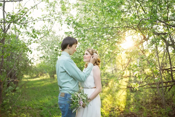 Älskar par stående bland blommande äppelträd — Stockfoto