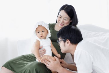  Daha uzakta anne ve kızı dinleniyor ve beyaz yatak odasında mutlu tatlı aile arka planda ve ev kavramında kalmak 