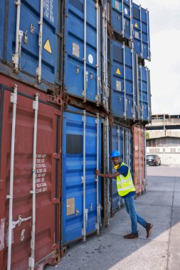 Amerikan siyah ustabaşı Tayland 'daki depo konteynırındaki kargo lojistik servis alanındaki konteynırın kapısını kapatmaya çalışıyor. 
