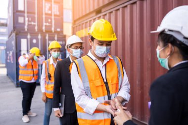 İşçi Mühendis Vücut Sıcaklığı Denetleme Yöneticisi Çalışan konteynır sitesinde kızılötesi termometre tabancalı Covid19 Virüsü