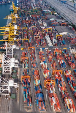 Depo konteynırlarını üst üste istifleme grubu ve vinçler konteyner gemisi ve araç lojistik fotoğrafıyla ithal edilen mal ve hizmetlerin dağıtımı için ticari liman iş merkezine yükleme yapıyor.