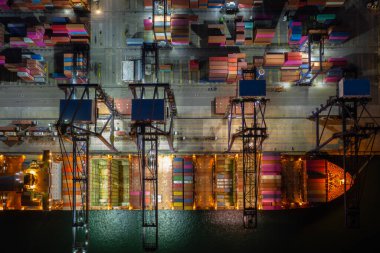 Gece sahnesi konteynır gemisi derin deniz limanında yükleme ve boşaltma, iş hizmetleri ve endüstriyel kargo lojistik ithalat ve ihracat taşımacılığı açık denizde konteyner gemisi, kargo nakliye gemisi yükleme.