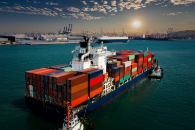 Uluslararası konteynır konteynırı ticari ticaret lojistik ithalatında ticari konteynır taşıyordu ve uluslararası taşımacılık konteynır gemisiyle güneş ışığı uluslararası liman arka planı üzerinden sabah 