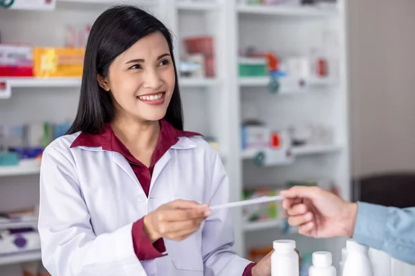 Азиатская Женщина Фармацевт Получает Бумажный Список Лекарств Пациентов Мужского Пола — стоковое фото
