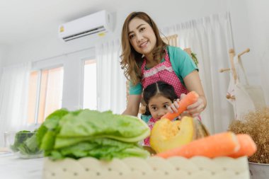 Anne ve kız, mutfakta salata yapmak için birbirlerine yardım ediyorlar. Ulusun virüse direnmesine yardım ediyorlar. 19 konsept ve seçici odaklanma.