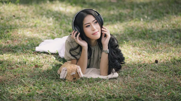 Όμορφη Ασιατική Γυναίκα Ξαπλωμένη Χαλαρώστε Και Ακούγοντας Ακουστικά Bluetooth Μουσική — Φωτογραφία Αρχείου