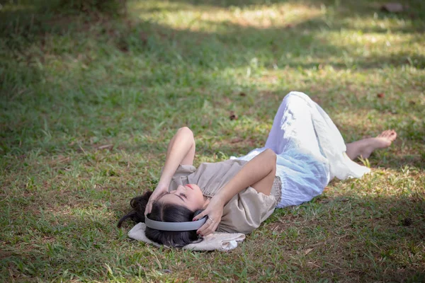 Женщины Азиатская Девушка Спит Наушниками Прослушивания Bluetooth Цифровой Музыки Парке — стоковое фото