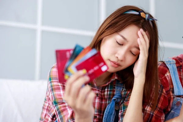 Sad asian woman having problem with limit credit card for online shopping couple renovations concept