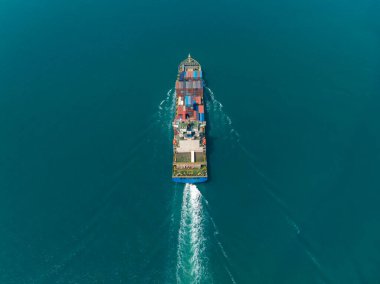 aerial view of large container ship sailing on deep sea, fully loaded with multi-colored containers, reflecting global business maritime transport cargo logistics, 