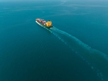 aerial view of large container ship sailing on deep sea, fully loaded with multi-colored containers, reflecting global business maritime transport cargo logistics, 