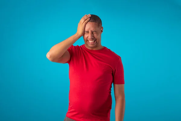 Mavi arka planda kırmızı tişörtlü bir yetişkin, çeşitli yüz ifadeleri yapıyor..