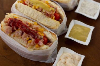 Lezzetli sosisli sandviç ve renkli ya da ahşap arka plan..