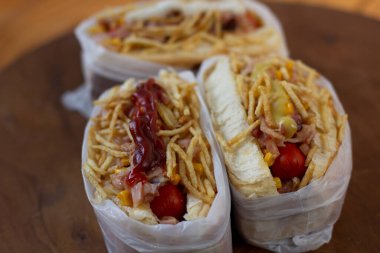 Lezzetli sosisli sandviç ve renkli ya da ahşap arka plan..