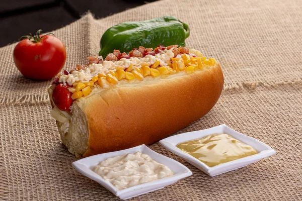 Lezzetli sosisli sandviç ve renkli ya da ahşap arka plan..