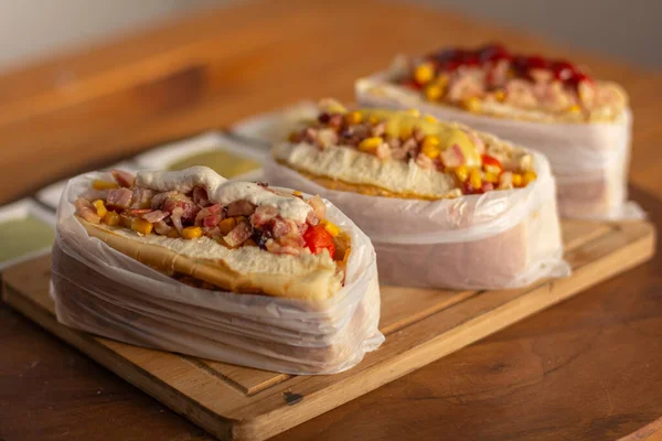 Lezzetli sosisli sandviç ve renkli ya da ahşap arka plan..