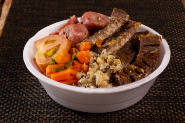 Brezilya beslenme çantasıyla ızgara et sosis salatası pirinç fasulyesi ve farofa.