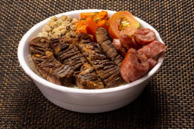 Brezilya beslenme çantasıyla ızgara et sosis salatası pirinç fasulyesi ve farofa.