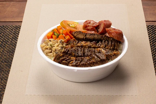 Brezilya beslenme çantasıyla ızgara et sosis salatası pirinç fasulyesi ve farofa.