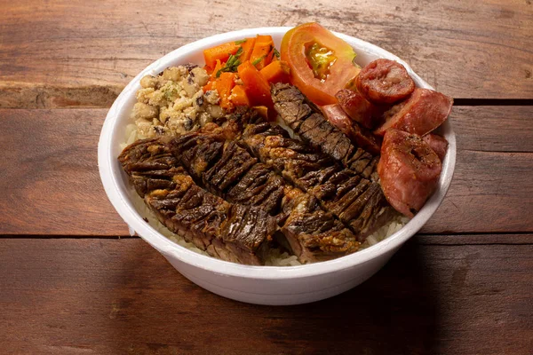 Brezilya beslenme çantasıyla ızgara et sosis salatası pirinç fasulyesi ve farofa.