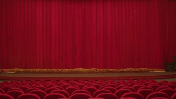 演出前的红色剧场帷幕和有聚光灯的红色剧场椅子 — 图库视频影像