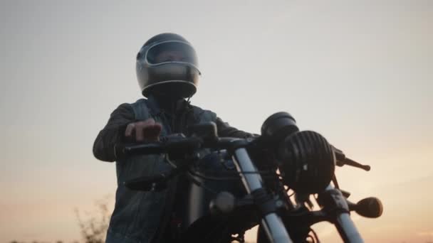 Motociclista Ajustando Casco Con Cielo Atardecer Fondo — Vídeo de stock
