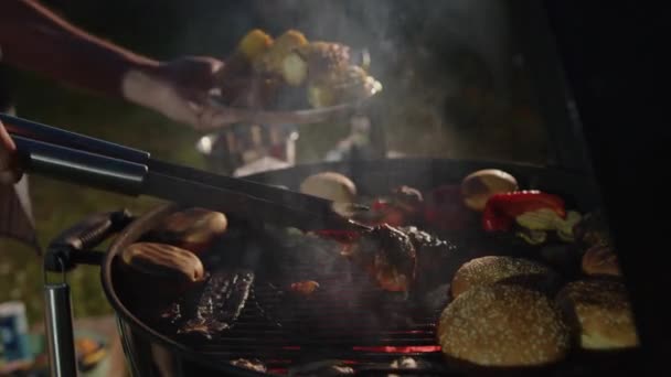 男の手には焼き野菜のプレートとグリルチキン肉のトングが付いています — ストック動画