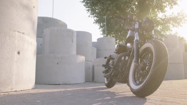 在太阳光照射下定制的摩托车的特写镜头 背景为混凝土环 — 图库视频影像
