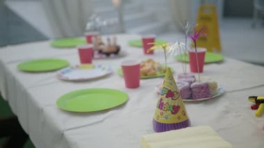 Renkli kağıt tabaklar ve gözlüklerle, renkli doğum günü konisi şapkalarıyla, pastalarla ve tabaklarla mutlu yıllar.