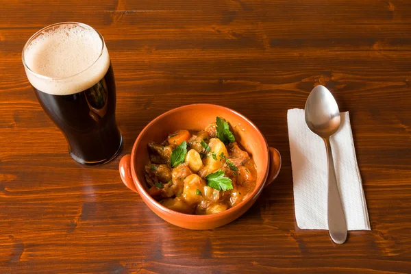 Estofado tradicional irlandés con una pinta de cerveza fuerte y una cuchara —  Fotos de Stock