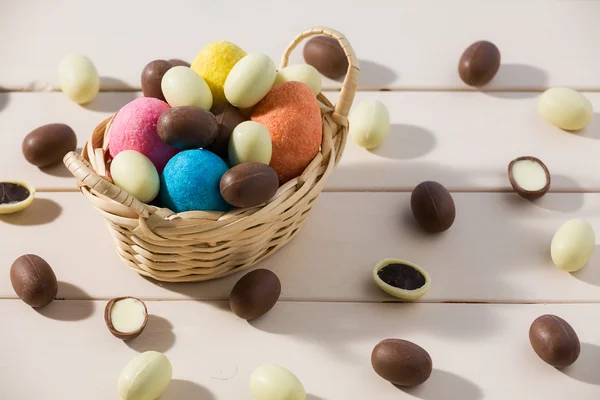 Ovos de chocolate de Páscoa em uma pequena cesta sobre uma mesa — Fotografia de Stock