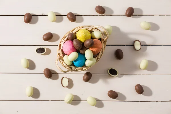 Ovos de Páscoa coloridos em uma pequena cesta vista de cima — Fotografia de Stock