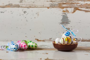 Ahşap bir kase içinde el yapımı boyalı Paskalya yumurtaları