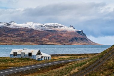 İzlanda 'nın doğu yakasındaki Faskrudsfjordur ve bulutlu bir günde eski bir çiftlik.