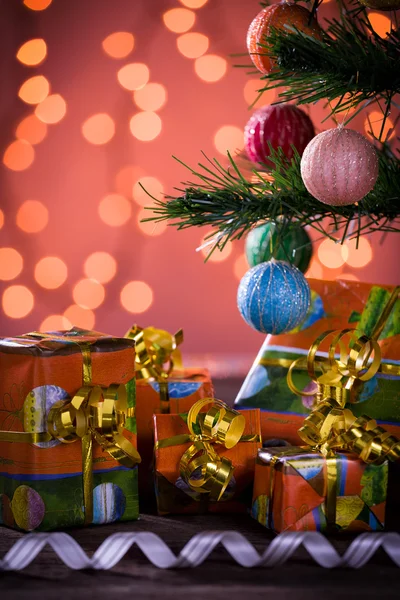 Christmas gifts with blurred lights and ribbon — Stock Photo, Image