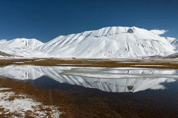 Sibillini mountains reflected in the water with snow — Stock Photo, Image