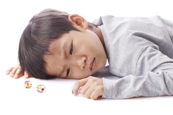Koncentrat chłopiec gra kostki na stole — Zdjęcie stockowe