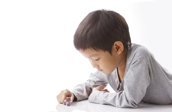 Concentrado niño juega dados en la mesa — Foto de Stock