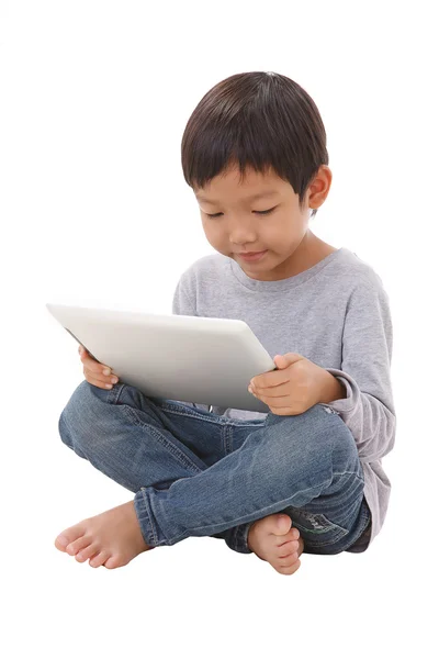 Мальчик за планшетом, сидя на полу — стоковое фото