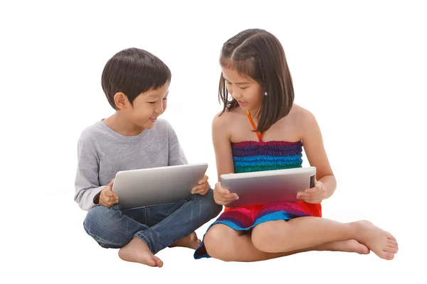 Мальчик и девочка с помощью планшета, сидя на полу — стоковое фото