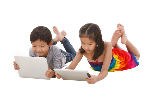 Мальчик и девочка с помощью планшета, лежа на полу — стоковое фото