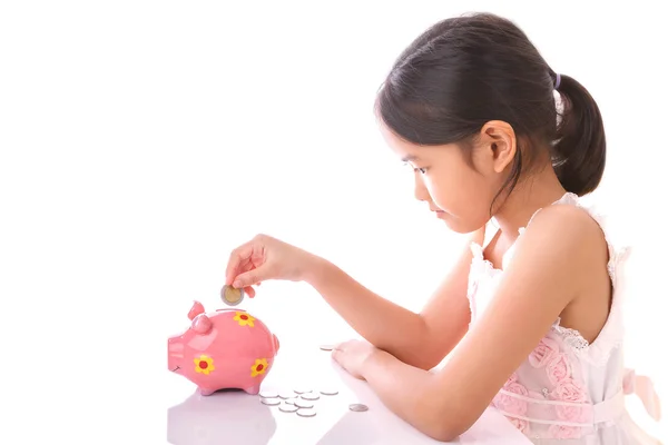 Little girl insert coin into piggy bank on white background — Stock Photo, Image