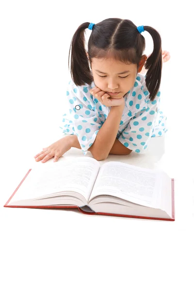 アジアのかわいい女の子をしながら本を読んでは、床に横たわった。白バック — ストック写真