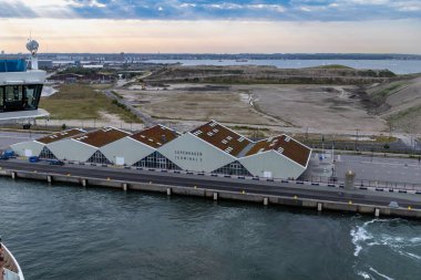 Kopenhag, Danimarka-14 Ağustos 2025: Kopenhag Terminali işaretli, deniz ve sanayi manzarasına bakan, yeşil çatıları olan modern gemi terminali..